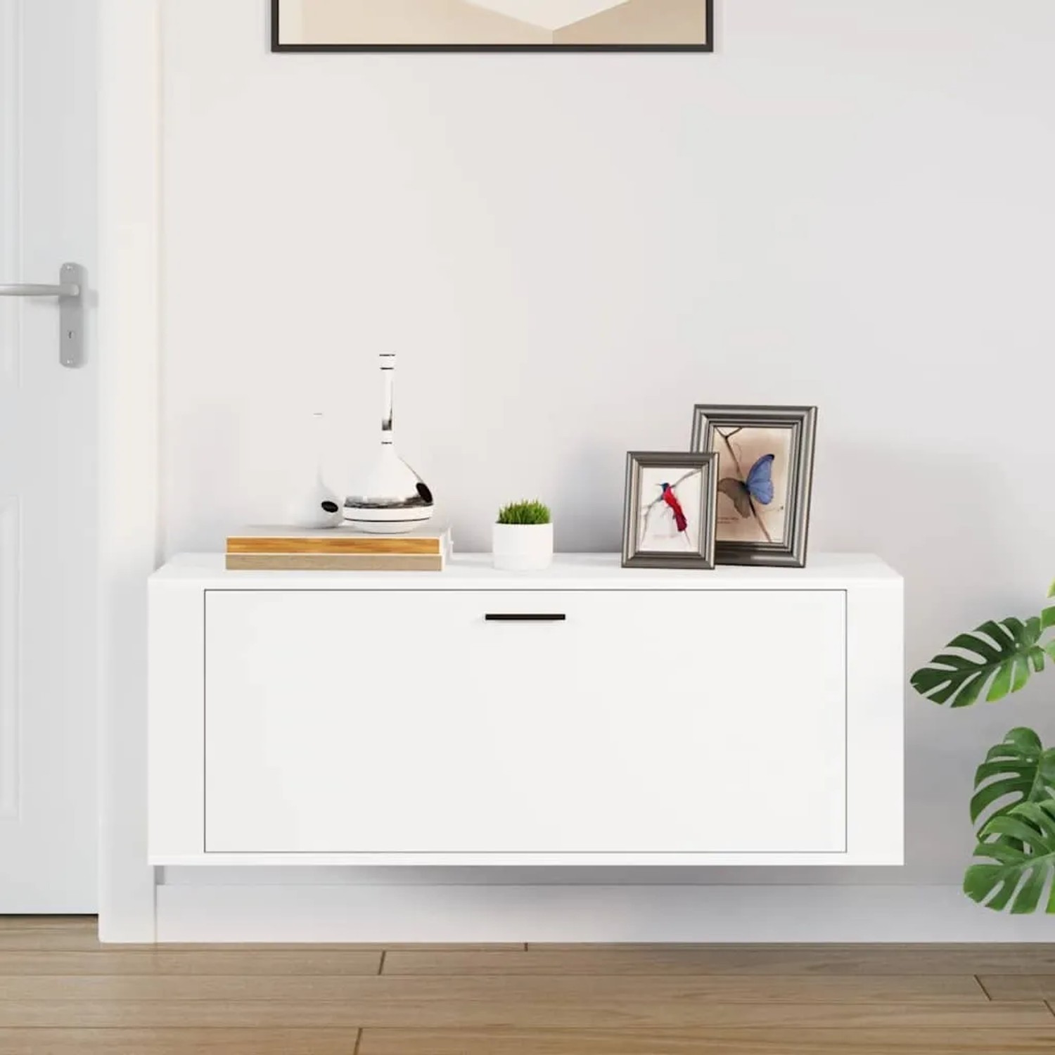 Weißer Wand-Schuhschrank aus Holzwerkstoff mit Klapptür und Ablagefläche, modern im Flur.