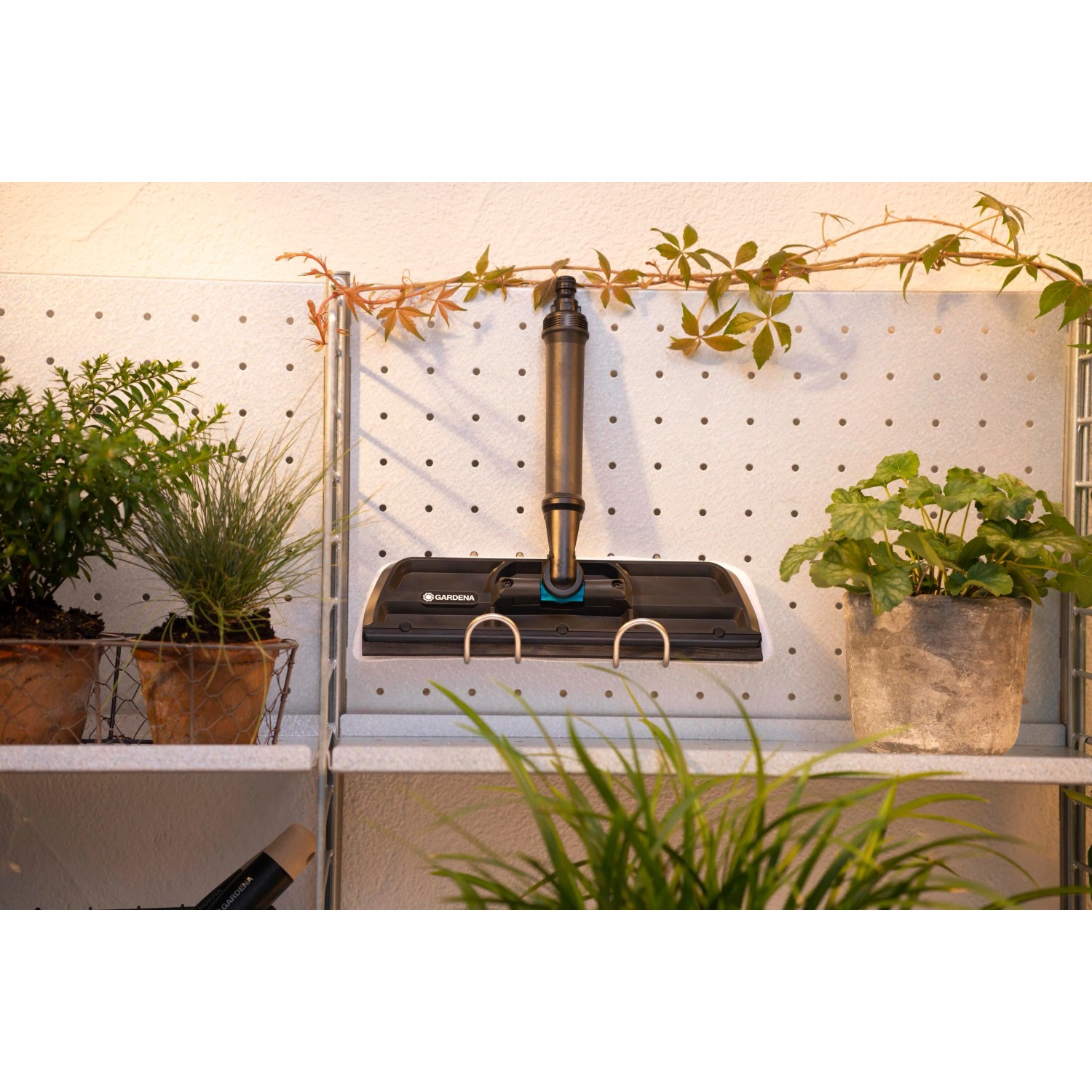 Gardena Cleansystem Fensterwischer mit Mikrovlies und Abziehlippe, hängend an einer Wand.
