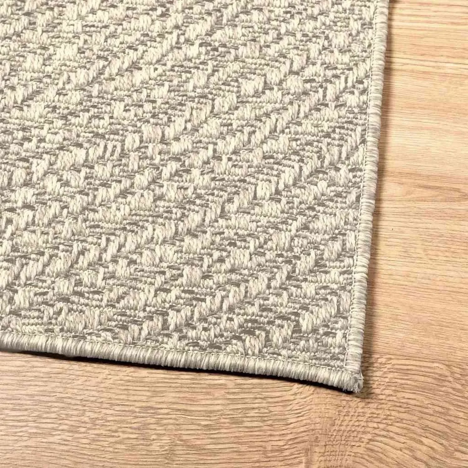 Cremefarbener vidaXL ZIZUR Teppich in Jute-Optik mit Chevron-Muster für Indoor & Outdoor auf Holzfußboden.