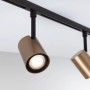 Zwei Paulmann URail Schienenspots Luxe in Gold matt und Schwarz an der Decke. Ein LED-Spot leuchtet hell.