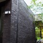 Schwarze Lutec LED-Solarleuchte Tuda mit 3 Leuchten an einer Hauswand.