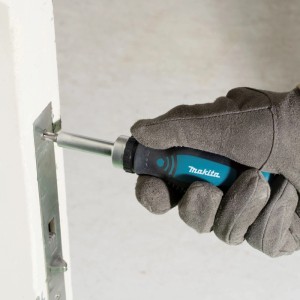 Makita Ratschenschraubendreher D-58833, Hand mit Handschuh schraubt in Metallplatte. Rutschfester Griff.