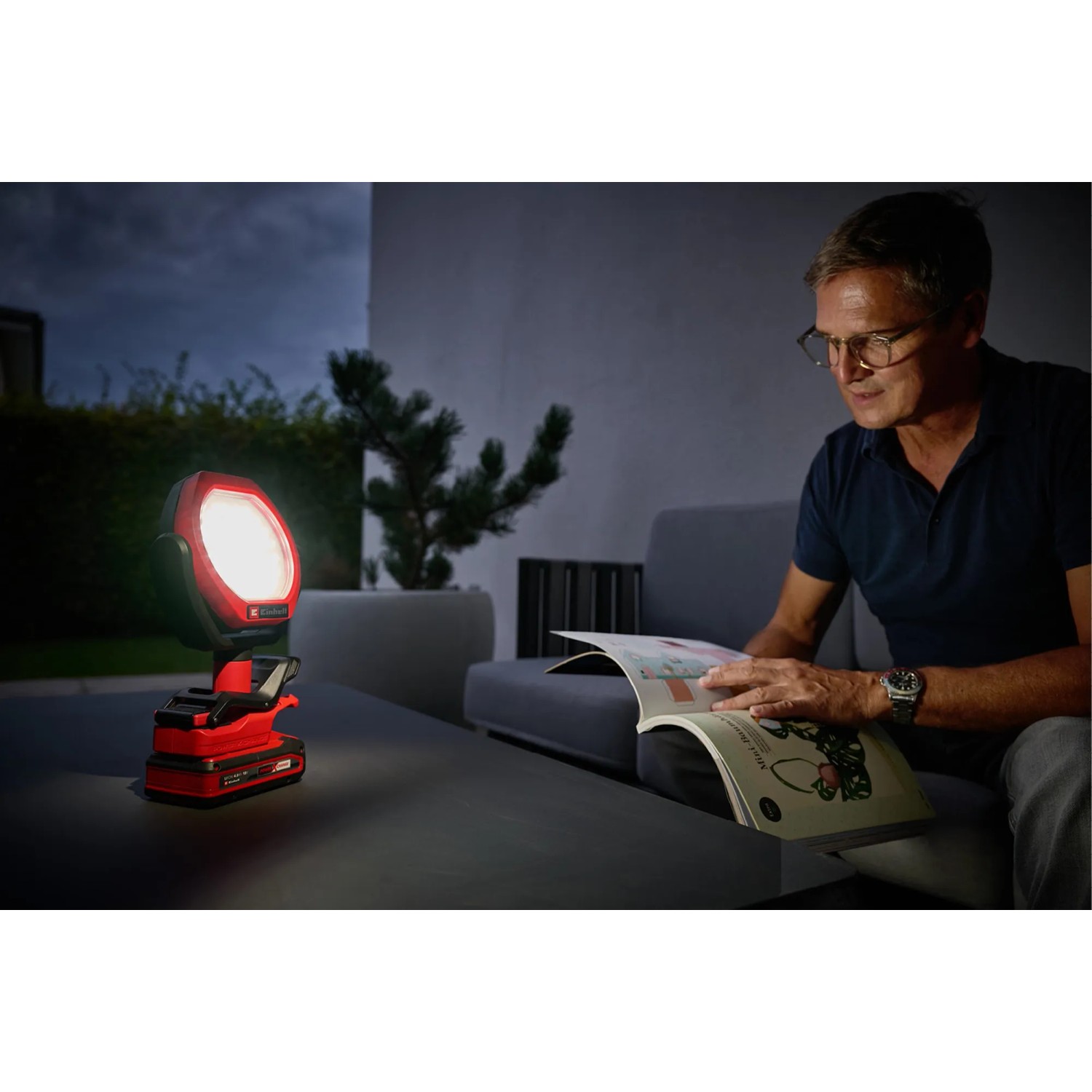 Einhell Akku-Outdoor-Lampe GC-OL 18/1500 Li-Solo im Einsatz beim Lesen im Garten.