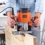 Black+Decker Oberfräse KW1200E in Aktion beim Fräsen von Holz.