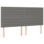 Dunkelgraues Boxspringbett Kopfteil mit horizontalen Ziernähten und Holzfüßen.