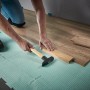 Verlegen von Laminat mit dem wolfcraft Verlege-Set: Zugeisen, Schlagholz und Keile im Einsatz.