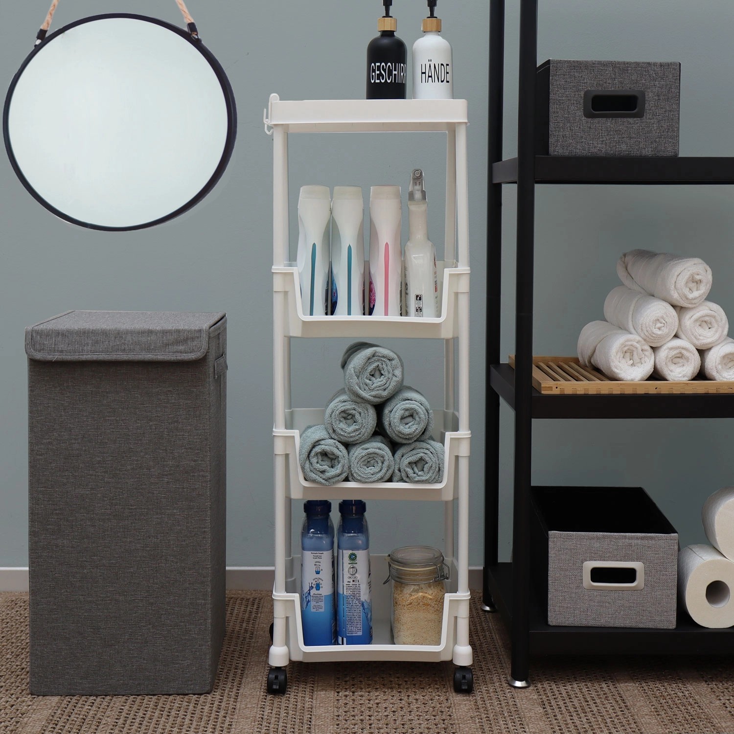 Weißer MAKLIK Küchenrollwagen mit 3 Körben (35x24x100 cm) im Badezimmer mit Handtüchern und Pflegeprodukten.