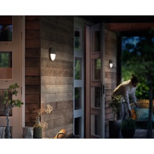 Philips myGarden Capricorn LED-Außenwandleuchte mit Bewegungsmelder an Holzfassade.