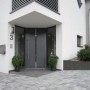 Anthrazitfarbener Diephaus L-Stein unbewehrt als Beeteinfassung vor einem Haus.