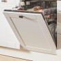 Offene, vollintegrierte Spülmaschine in weißer Küchenzeile. Geschirr ist im Innenraum sichtbar.