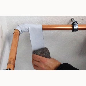 Anwendung von Scorprotect Vlies Wickelband mit Dampfsperre an einem Heizungsrohr.