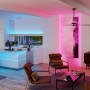 Paulmann MaxLED-Streifen in Blau und Pink beleuchten modernes Wohnzimmer und Küche. Flexible RGBW LED-Beleuchtung für Ecken und kreative Gestaltung.
