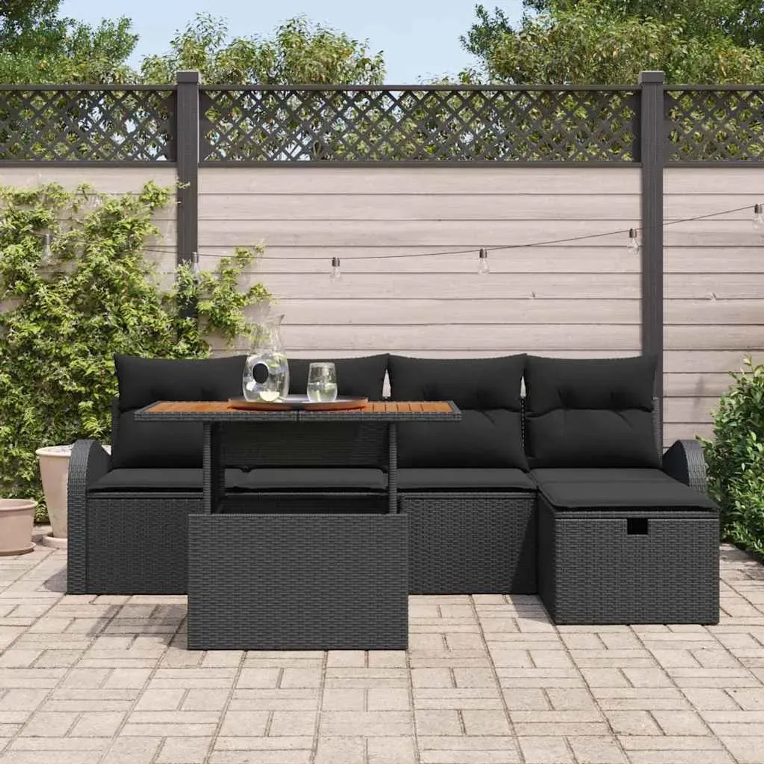 Schwarzes 6-teiliges Garten-Sofa-Set aus Poly Rattan mit Tisch und Kissen.