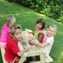 Soulet Kindersitzgarnitur mit Sandkasten im Garten mit spielenden Kindern.