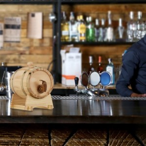 Helles Holzfass mit Zapfhahn und Bock auf einer Bar. Ideal für Wein, Whiskey und Spirituosen als Geschirr.