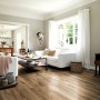 Wohnraum mit Egger Aqua-Laminatboden EL1071 NatureSense Perganti Nussbaum Braun.