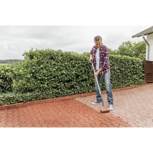 Mann trägt Ultrament Betonlasur Pflaster Frisch Rot auf Pflastersteine auf.