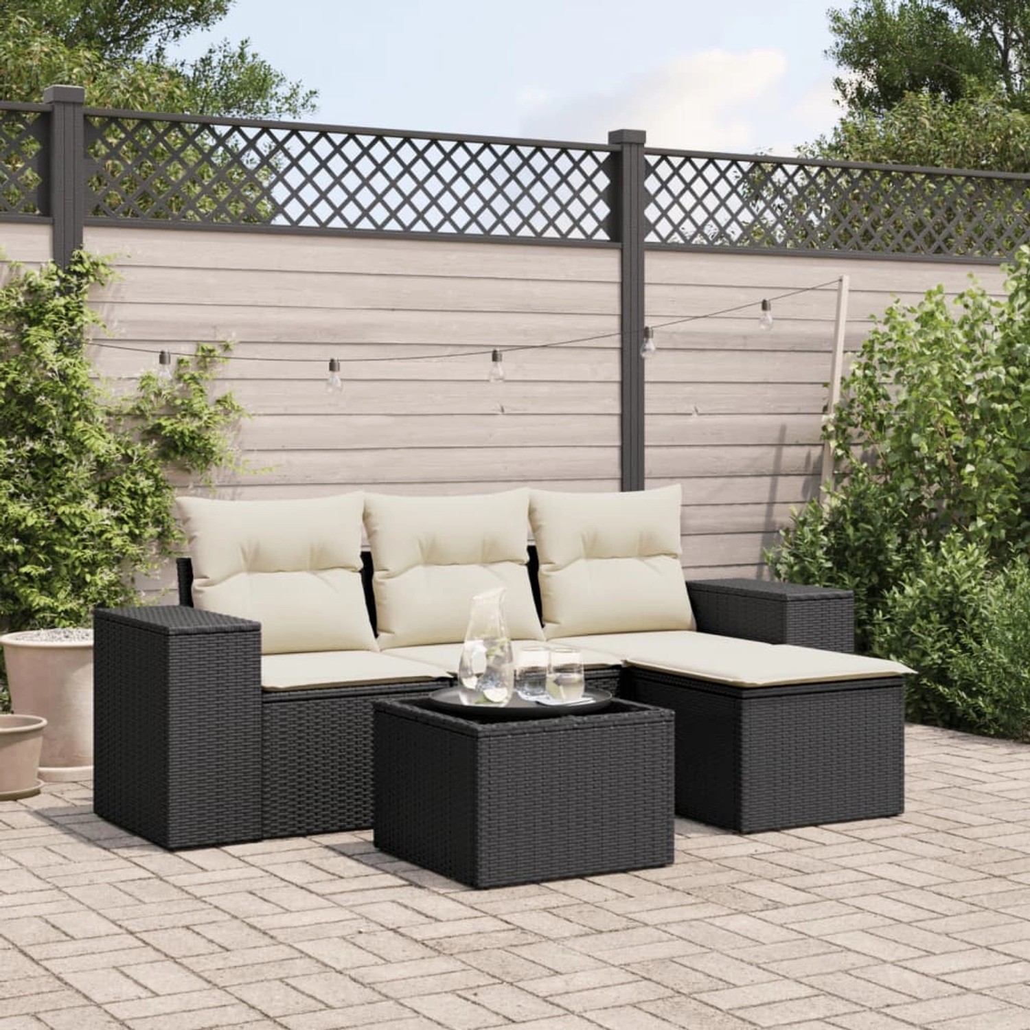 Schwarze 5-tlg. Garten-Sofagarnitur aus Poly Rattan mit cremefarbenen Kissen. Gartenmöbel-Set mit Tisch und Stauraum.
