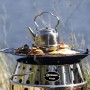 Petromax Grillplatte für Atago mit Speisen und Teekessel auf dem Grill.