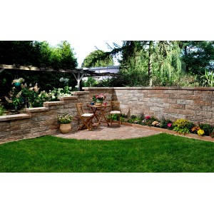 Garten mit Bruchsteinmauer Jura-Nuanciert, Endelement und Sitzgruppe auf Terrasse.