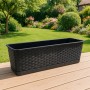 Anthrazitfarbener Blumenkasten 80 cm in Rattan-Optik mit Untersetzer auf Holzterrasse. Ideal für Balkon & Garten.