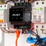 Shelly Relaismodul Pro 3 Schwarz im Schaltschrank mit LAN-Kabel für Hausautomation.