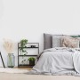 Schwarzer, eckiger Digitalwecker mit großen weißen Ziffern auf Regal im modernen Schlafzimmer.