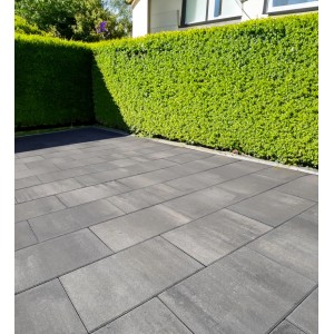 Verlegte EHL Artano Terrassenplatten, 60x40 cm, grau-anthrazit, mit Hecke im Hintergrund.