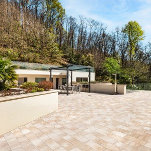 Verlegte EHL Terrassenplatten Lucca Sandstein, 60x26,6x5 cm, auf einer Terrasse mit Gartenmöbeln.
