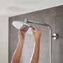 Hansgrohe Crometta S Showerpipe 240: Jemand reinigt die Chrom-Kopfbrause des Duschsystems.