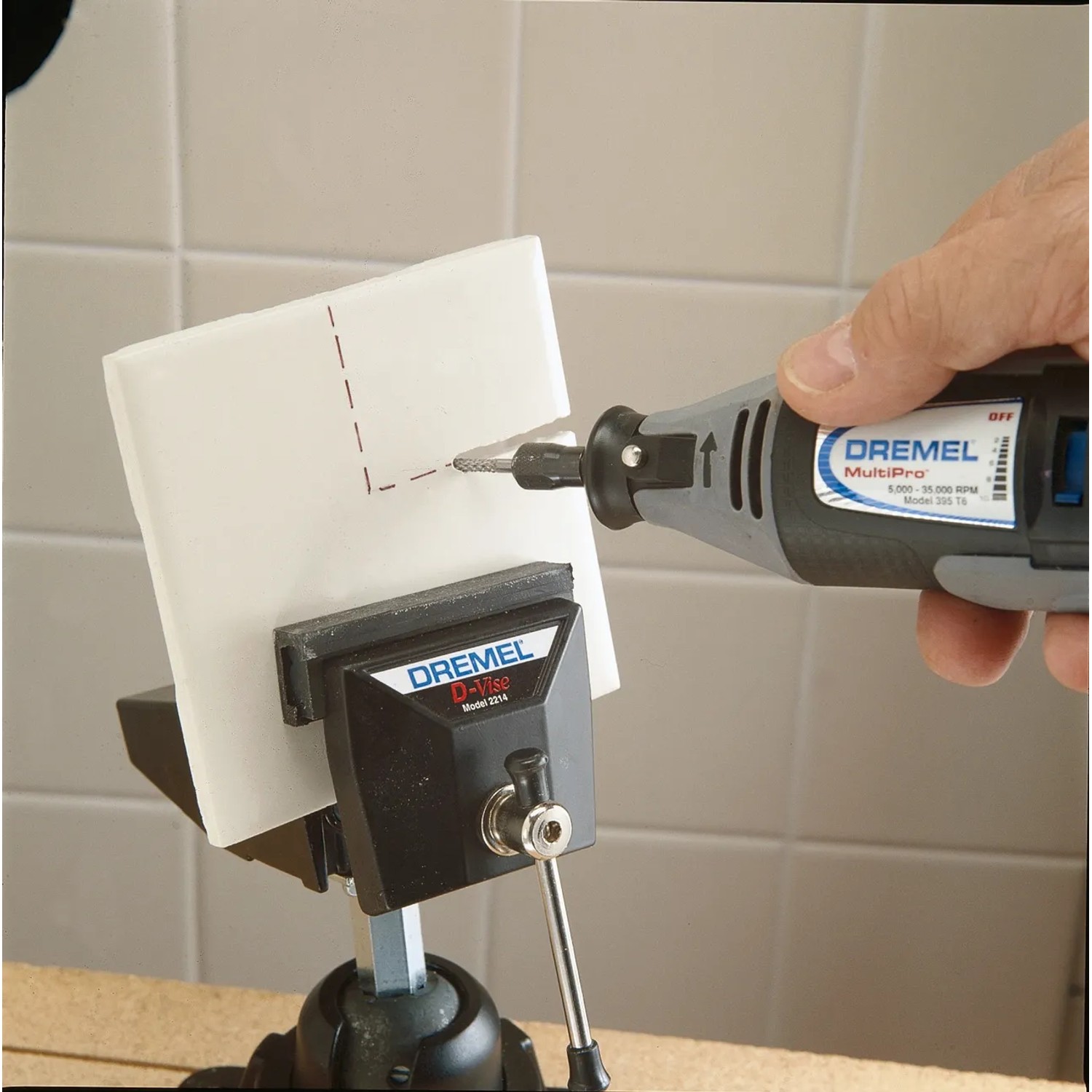 Dremel Spiralfräser 562 beim Fräsen einer Keramikfliese, eingespannt in einen Schraubstock.