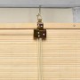 Sol Royal SolDecor B86 Bambusrollo, Nahaufnahme der Klemmfix-Montage am Fenster. Natürliche Bambuslamellen und goldener Halter.