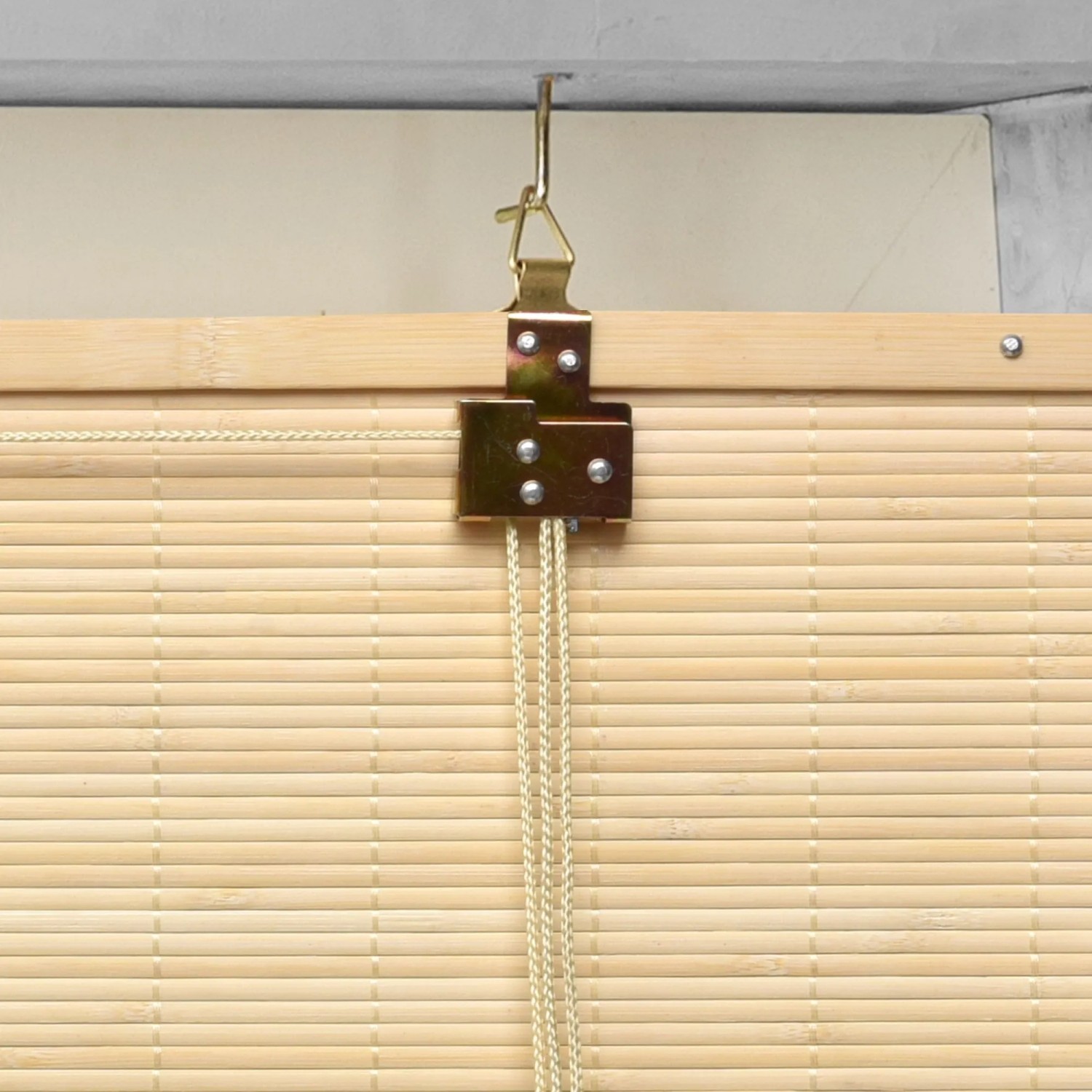 Sol Royal SolDecor B86 Bambusrollo, Nahaufnahme der Klemmfix-Montage am Fenster. Natürliche Bambuslamellen und goldener Halter.