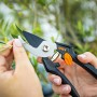 OBI Gartenschere im Einsatz beim Schneiden eines Triebs. Bypass-Schneidsystem, antihaftbeschichtete Klingen.