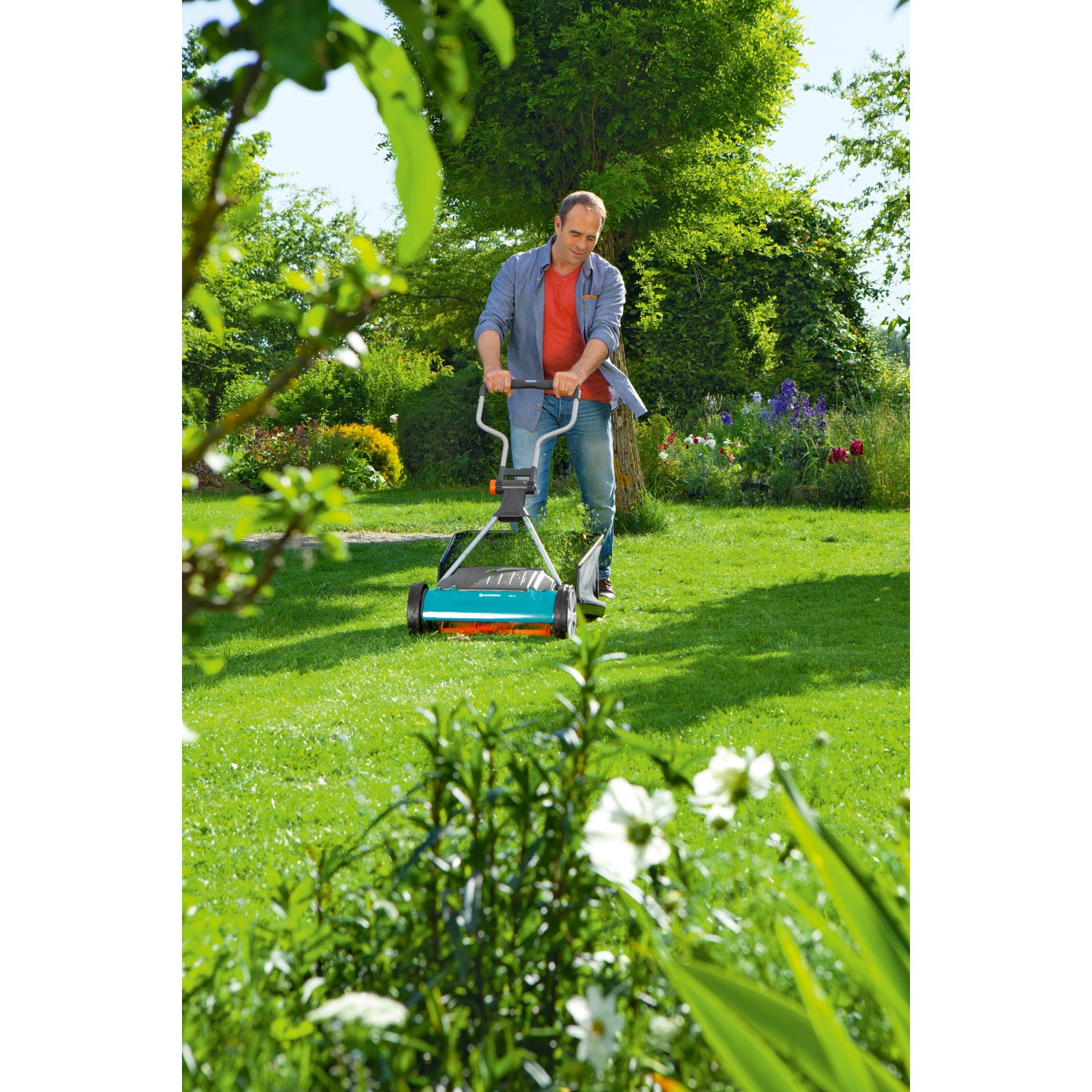 Mann mäht Rasen mit Gardena Comfort Spindelmäher 400 C. Handrasenmäher für präzisen Schnitt.