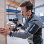 Mann schraubt mit Bosch Professional Akku-Schlagbohrschrauber GSB 18V-90 C in Holz.