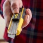 Stanley Cuttermesser FatMax 18 mm, schwarz-gelb, mit Klinge in der Hand.