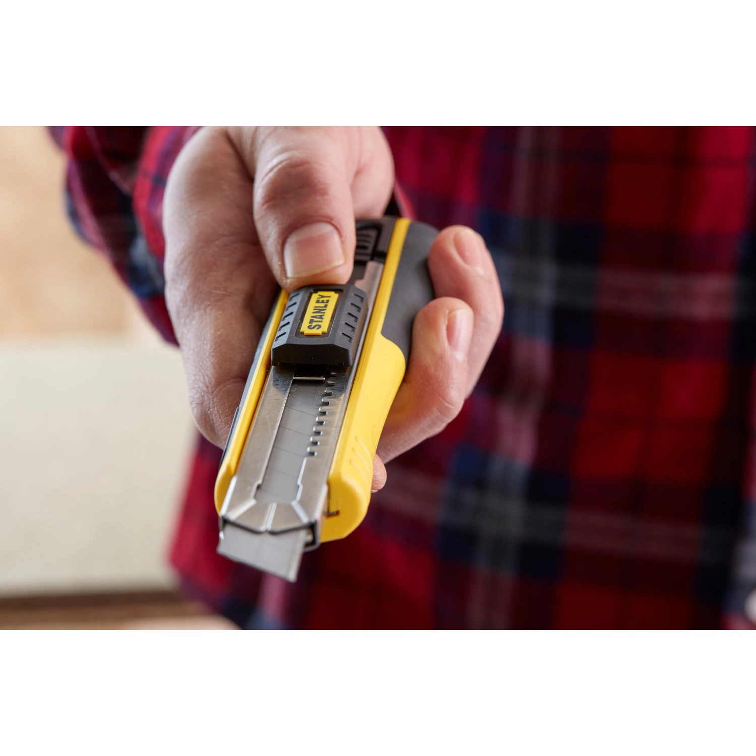 Stanley Cuttermesser FatMax 18 mm, schwarz-gelb, mit Klinge in der Hand.
