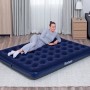 Bestway Luftmatratze Queen Size, dunkelblau, 203x152x22 cm, mit liegender Person im Wohnraum.