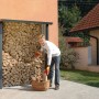Biohort Kaminholzregal WoodStock 150 in Quarzgrau-Metallic mit Holz und Person.