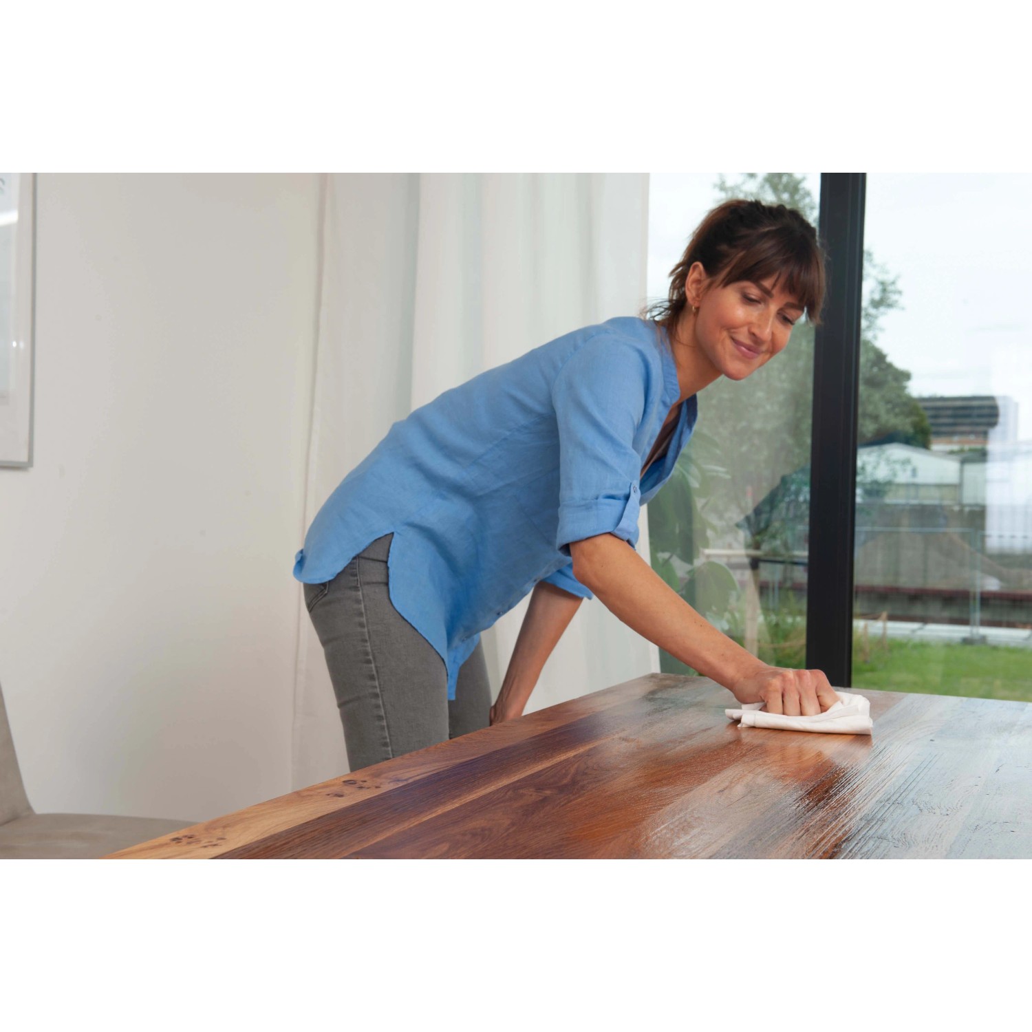 Frau ölt transparente Holz-Arbeitsplatte mit Bondex Arbeitsplatten-Öl.