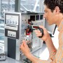 Mann schraubt mit Bosch Ixo Drehmoment-Aufsatz an PC. Zubehör für Schrauber.