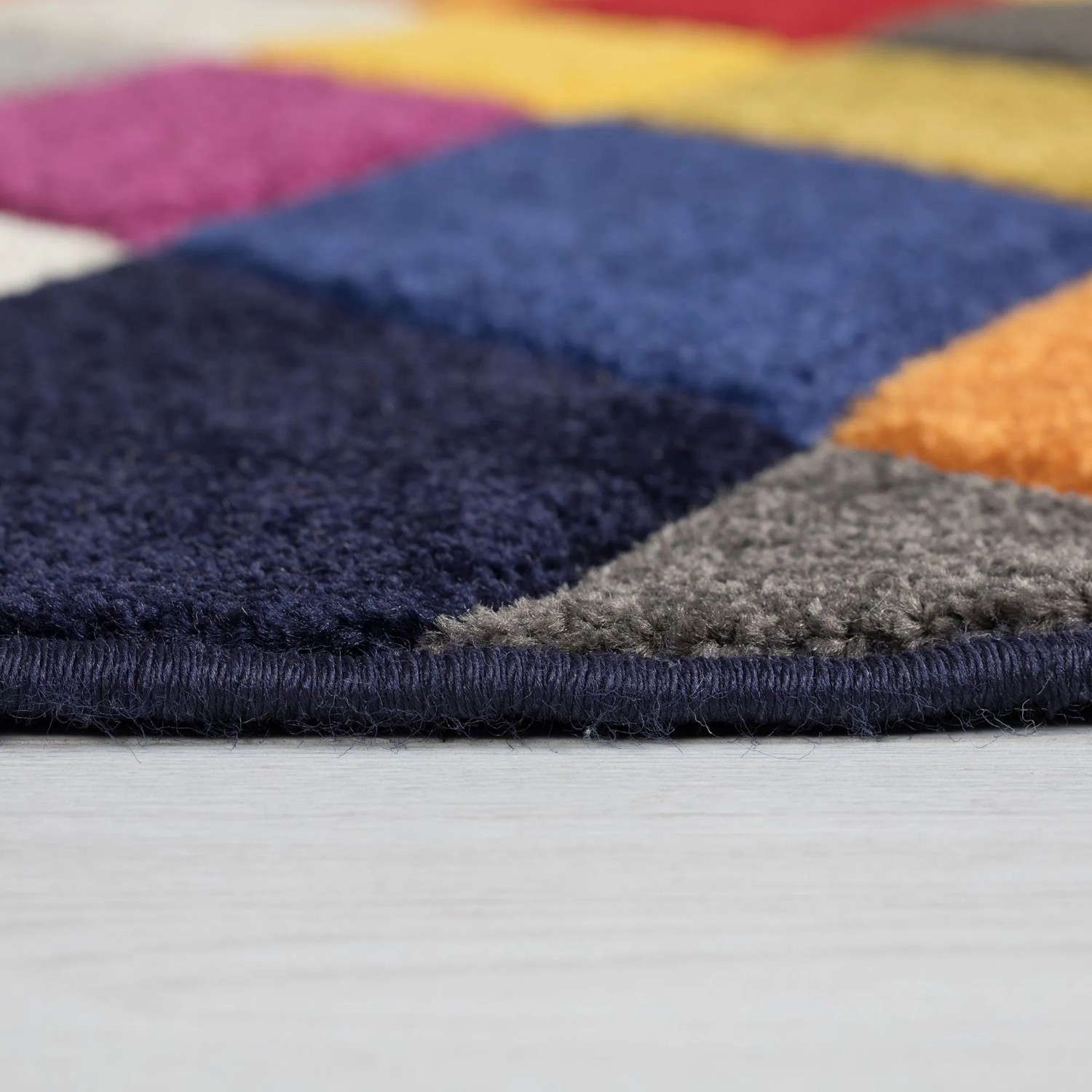 Flair Rugs Kinderteppich Rhumba: Nahaufnahme des mehrfarbigen, geometrischen Musters in Blau, Grau, Orange, Pink. Strapazierfähig.
