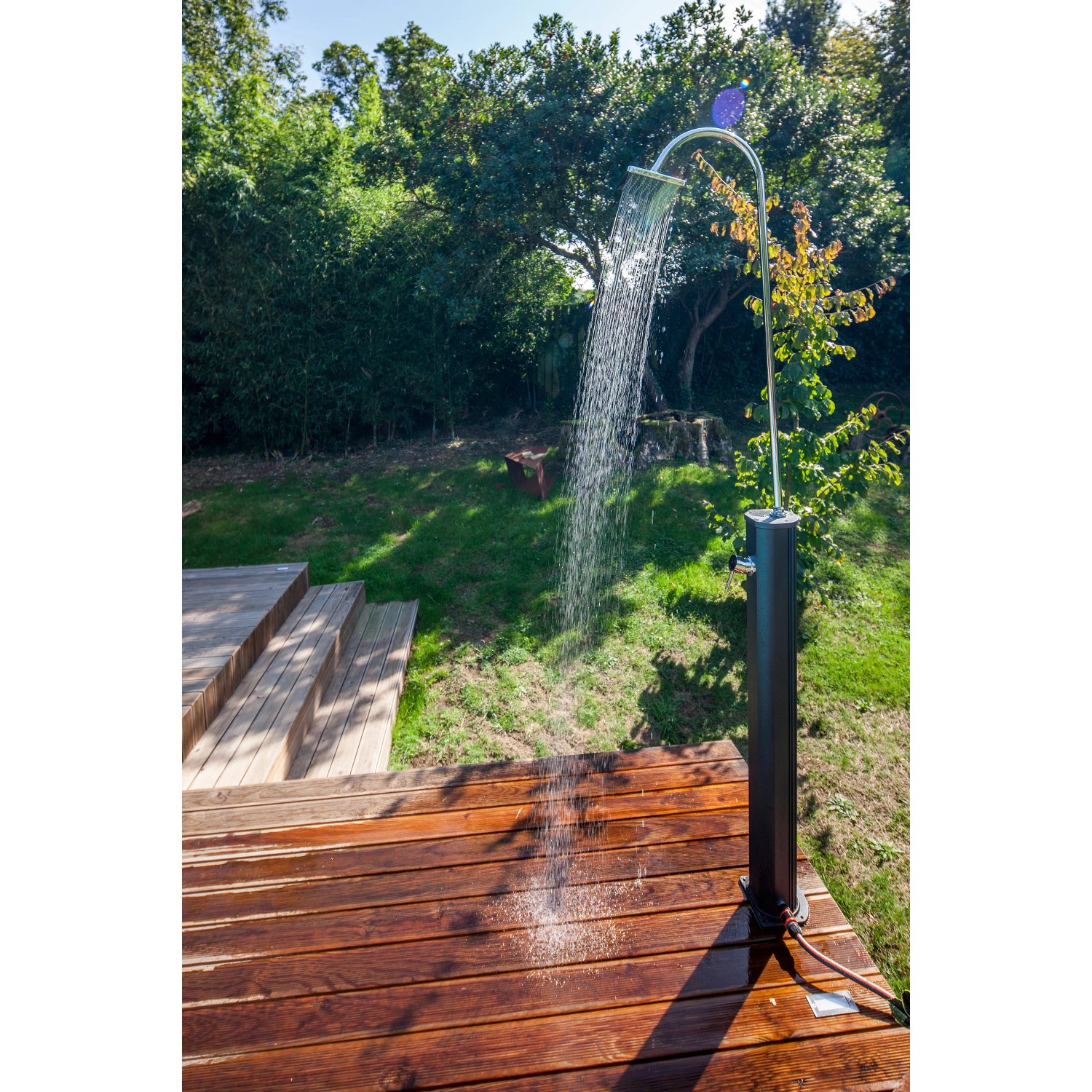 Schwarze Gre Solardusche aus Aluminium (18 l) im Garten mit laufendem Wasser.