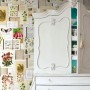 ESTAhome Fototapete mit botanischen Motiven in Beige, Grün und Rosa hinter weißem Schrank.