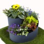 Graue Jardinion Kräuterspirale (35cm) bepflanzt mit Kräutern und Blumen auf Rasen.