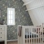 Dekorative Vliestapete mit blau-grünem Blumen- und Vogelmuster in einem Kinderzimmer.