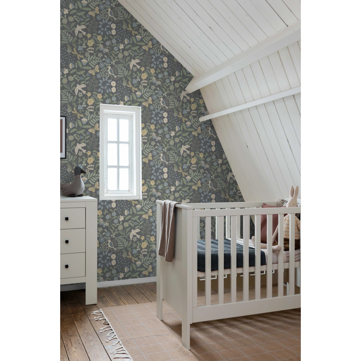 Dekorative Vliestapete mit blau-grünem Blumen- und Vogelmuster in einem Kinderzimmer.