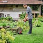 Einhell Akku-Rasentrimmer GE-CT 18/28 Li-Solo im Einsatz im Garten. Der Trimmer ist rot und silber.