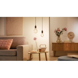 Philips Smart LED Filament Leuchtmittel, 7W E27 Globe, klares Glas, in Wohnraum-Szene.